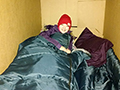  person bundled up in a refrigerator box